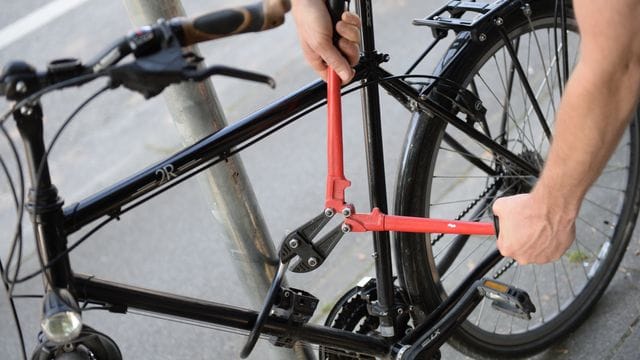 Ein Mann versucht ein Fahrradschloss aufzubrechen Ein Mann versucht ein Fahrradschloss aufzubrechen