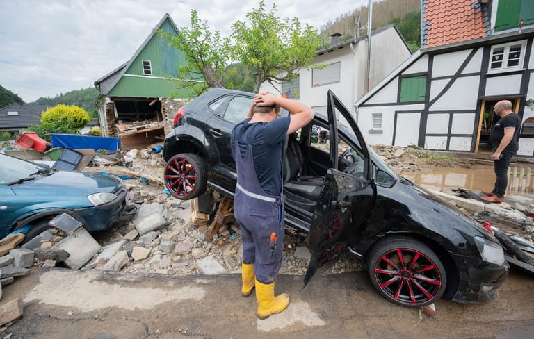 Hagen, Nordrhein-Westfalen: Ein Anwohner steht vor seinem zerstörten Auto im Ortsteil Hohenlimburg. Die Lage ist dramatisch.
