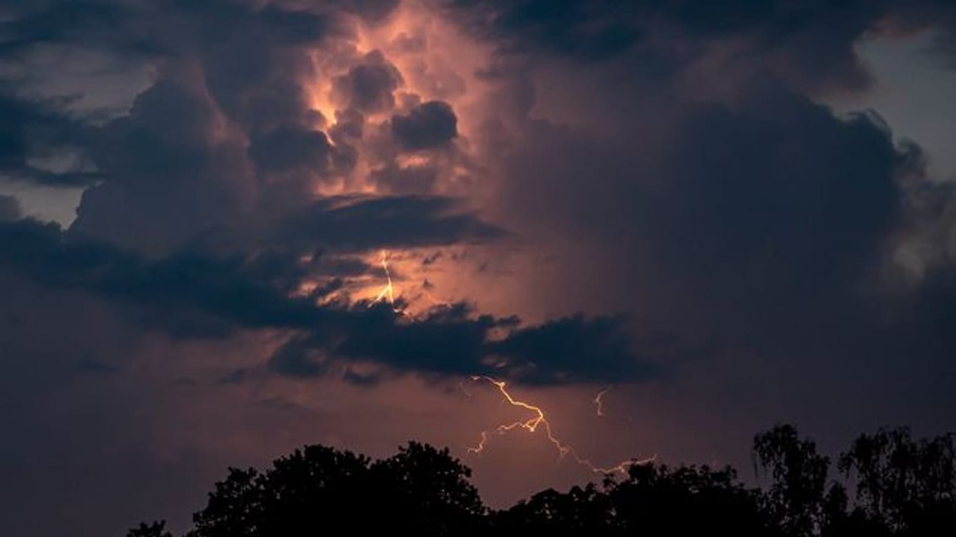 Ein Blitz hellt die dunklen Wolken auf