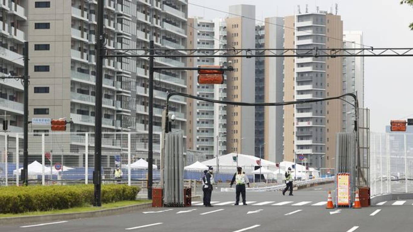 Sicherheitskräfte stehen vor dem Olympischen Dorf in Tokio.