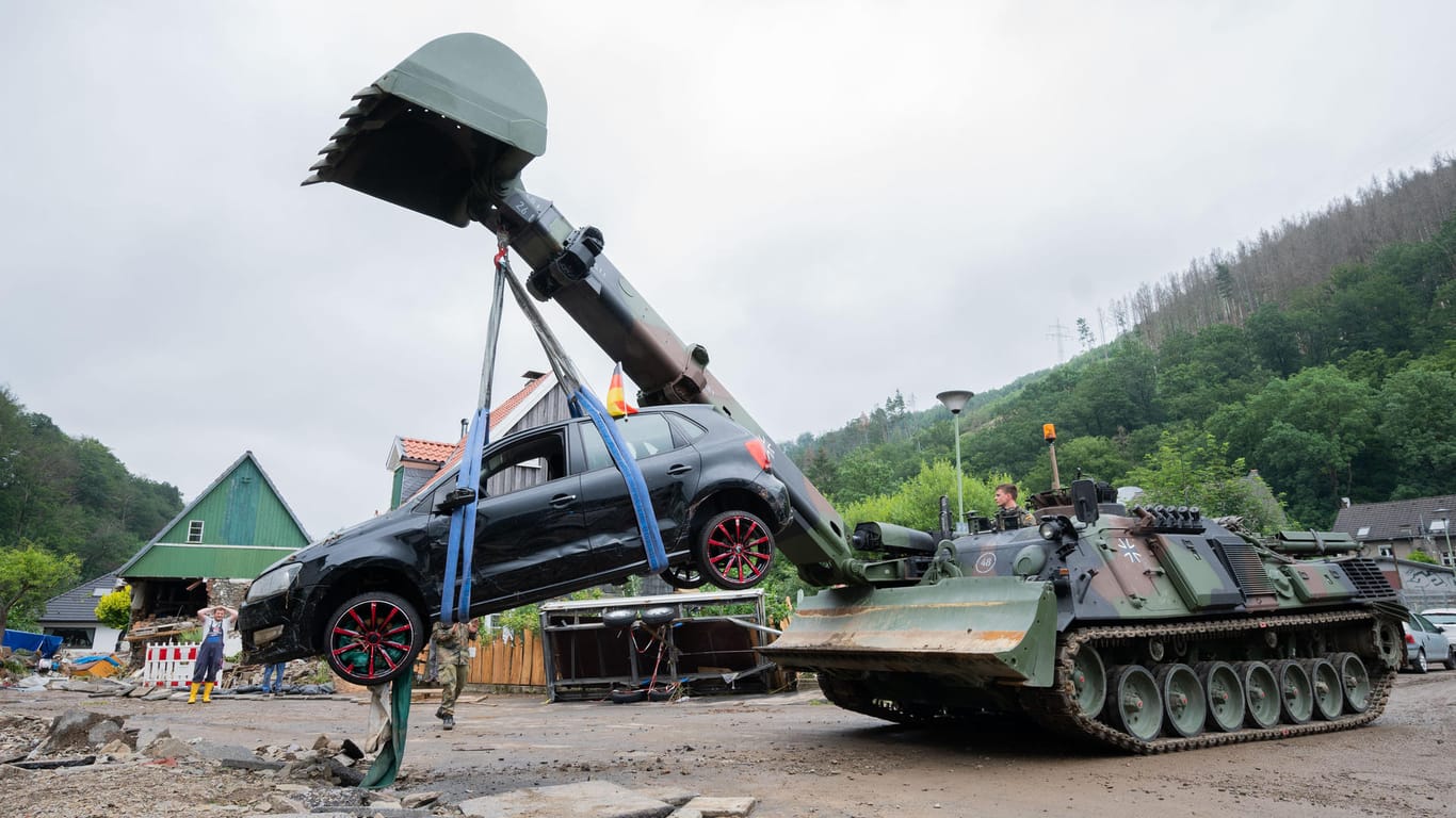 Soldaten der Bundeswehr bergen mit einem Pionierpanzer "Dachs" ein zerstörtes Auto in Hagen-Hohenlimburg: Bei den Aufräumarbeiten werden die schweren Unwetterschäden sichtbar.
