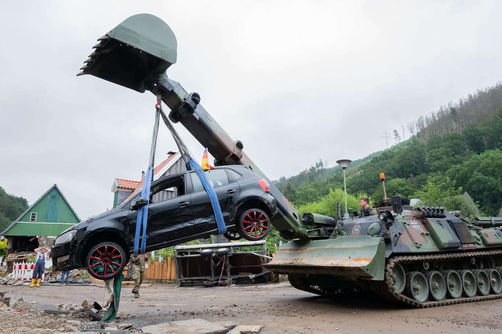 Soldaten der Bundeswehr bergen mit einem Pionierpanzer "Dachs" ein zerstörtes Auto in Hagen-Hohenlimburg: Bei den Aufräumarbeiten werden die schweren Unwetterschäden sichtbar.