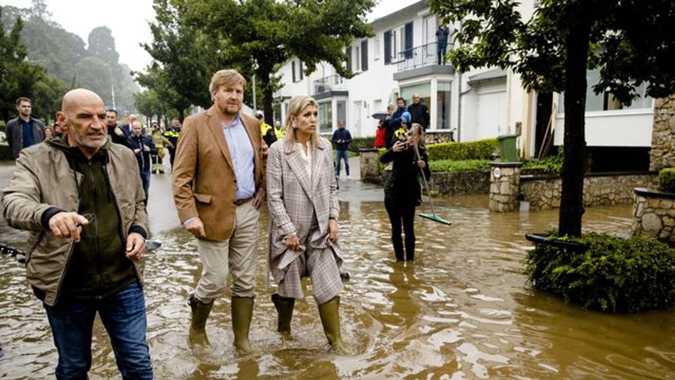 König Willem-Alexander der Niederlande (M) und Königin Máxima untersuchen die Schäden, die der Sturm in den letzten Tagen in Valkenburg angerichtet hat.
