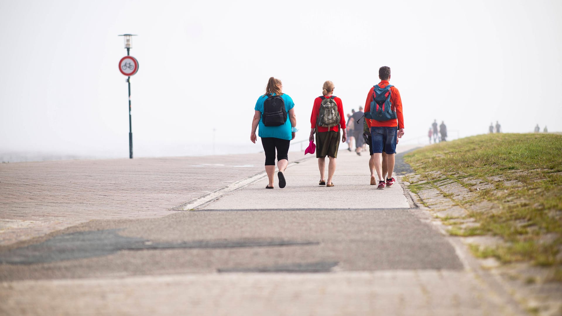 Touristen an einer Strandpromenade: Spaziergänge sind nicht nur am Meer wohltuend.