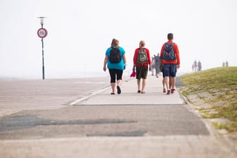 Touristen an einer Strandpromenade: Spaziergänge sind nicht nur am Meer wohltuend.