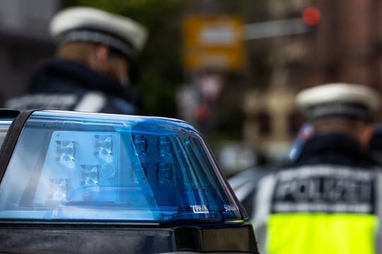 Zwei Polizeibeamte stehen zwischen Einsatzfahrzeugen (Symbolbild): Die Polizei schließt einen Straftatbestand aus.