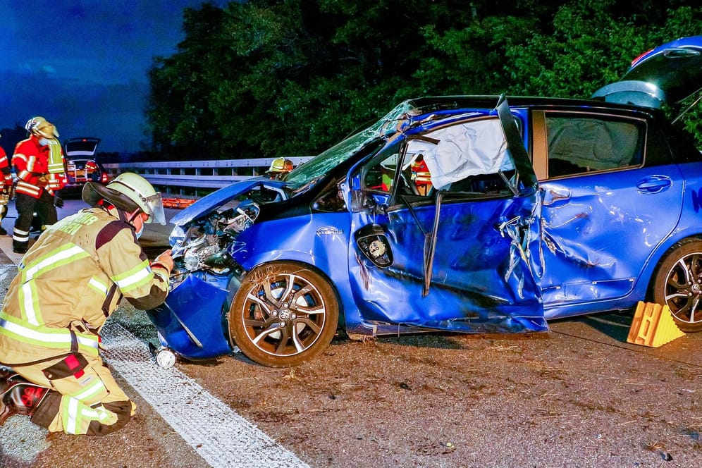 Ein Feuerwehrmann kniet an dem Unfallauto: Der Toyota Yaris ist aus bislang unbekannter Ursache ins Schleudern geraten.