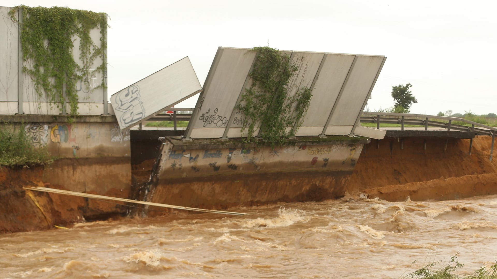 Ein Teil der Fahrbahn und der Lärmschutzwand stürzen in die Erft: Das Hochwasser hat die Autobahn bei Erftstadt stark beschädigt. Ein Teil der Fahrbahn und der Lärmschutzwand stürzen in die Erft: Das Hochwasser hat die Autobahn bei Erftstadt stark beschädigt.