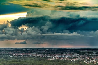 Eine Gewitterfront am Horizont über dem Stadtbild von Leipzig (Archivbild): Menschen in den betroffenen Gebieten sollen sich möglichst nicht im Freien aufhalten.