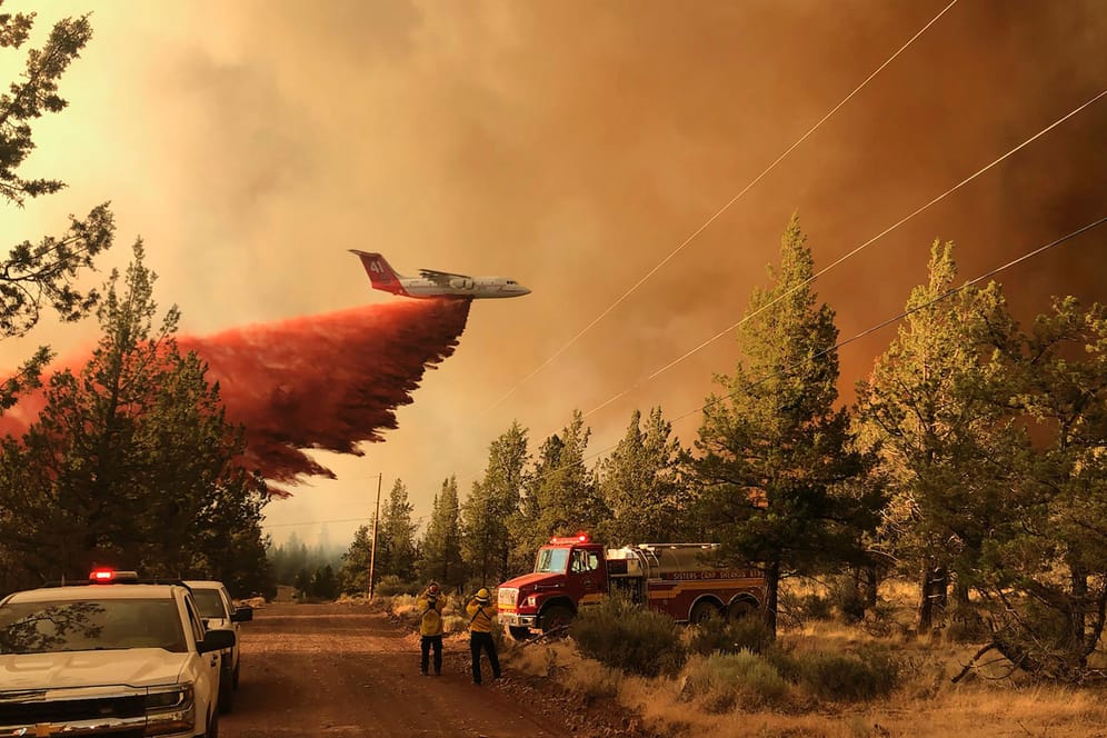 Ein Löschflugzeug fliegt über eine Straße in Oregon. Die Waldbrände weiten sich durch das trockene Wetter noch aus.