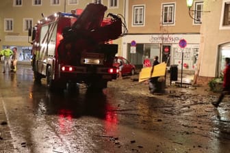 Nächtliche Aufräumarbeiten auf einer vom Hochwasser betroffenen Straße. Nach sintflutartigen Regenfällen sind in Österreich Teile der Altstadt von Hallein überflutet worden