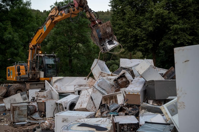 Kordel, Rheinland-Pfalz: Ein Bagger entsorgt Elektrogeräte, die durch das Hochwasser beschädigt wurden. Zahlreiche Häuser im Ort Kordel waren betroffen, Bewohner mussten evakuiert werden.
