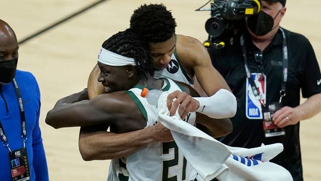 Giannis Antetokounmpo von den Milwaukee Bucks umarmt Teamkollege Jrue Holiday nach dem Sieg über die Suns. Giannis Antetokounmpo von den Milwaukee Bucks umarmt Teamkollege Jrue Holiday nach dem Sieg über die Suns.