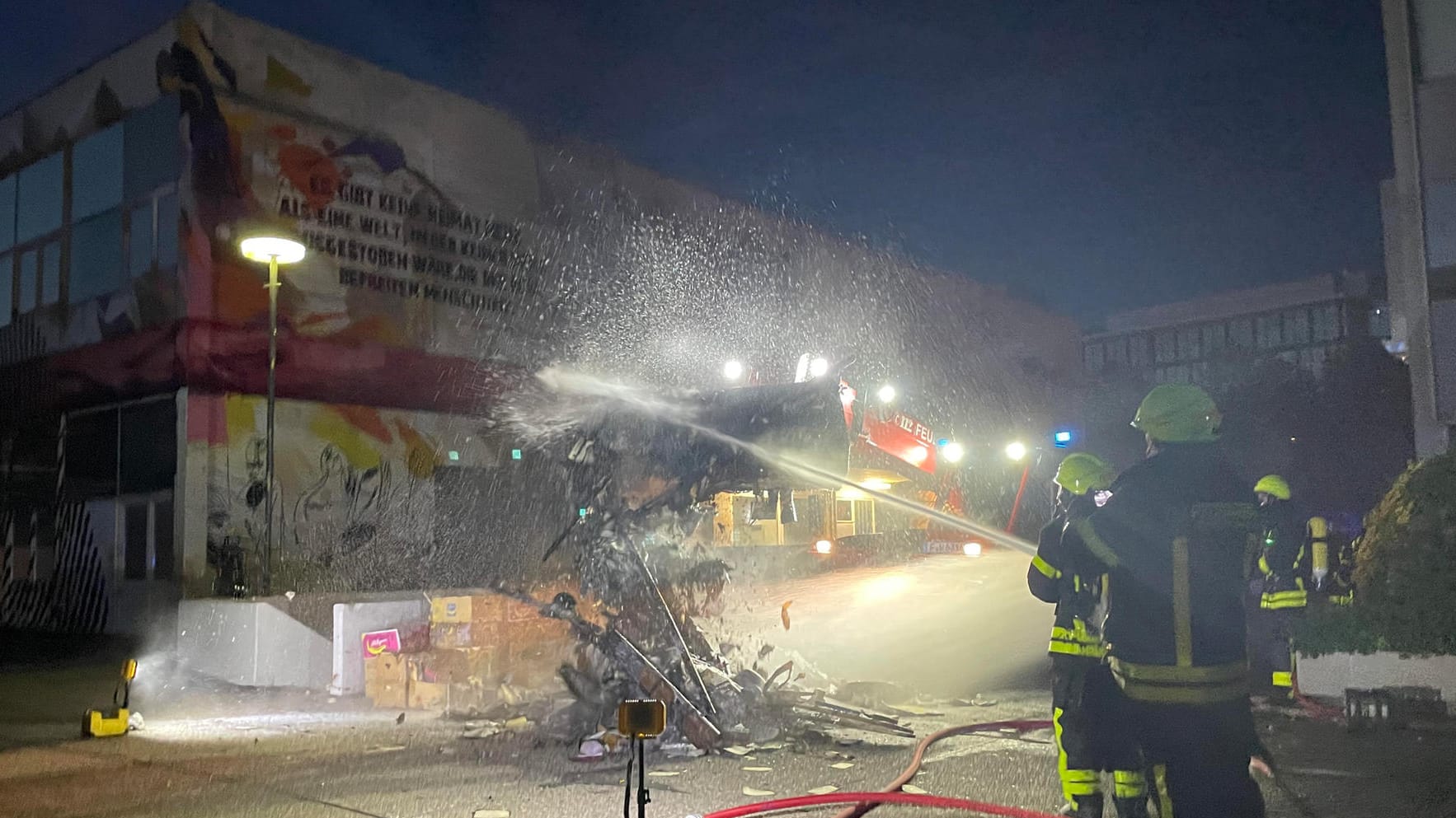 Feuerwehrleute löschen das Feuer am Uni-Campus: Der brennende Papierberg stellte die Einsatzkräfte vor eine Herausforderung.