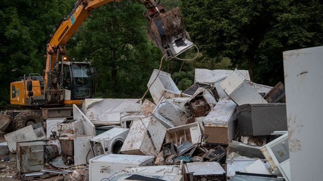 Ein Bagger entsorgt in Kordel (Rheinland-Pfalz) Elektrogeräte, die durch das Hochwasser beschädigt wurden.