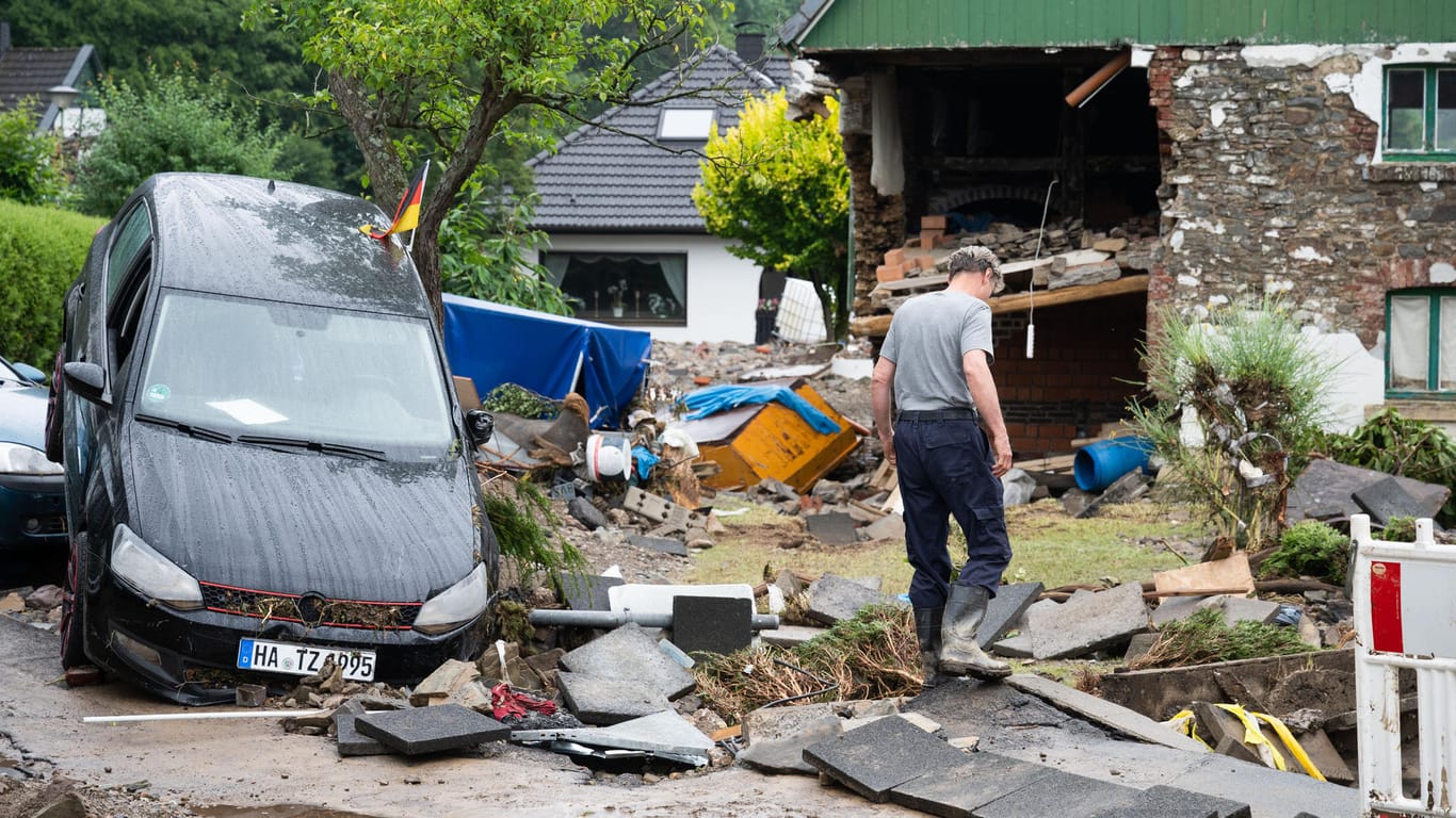 Ein Anwohner steht zwischen den Trümmern der Unwetterschäden im Ortsteil Hohenlimburg: In Hagen haben die Wassermassen ein Schlachtfeld hinterlassen.