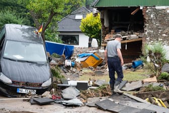 Ein Anwohner steht zwischen den Trümmern der Unwetterschäden im Ortsteil Hohenlimburg: In Hagen haben die Wassermassen ein Schlachtfeld hinterlassen.