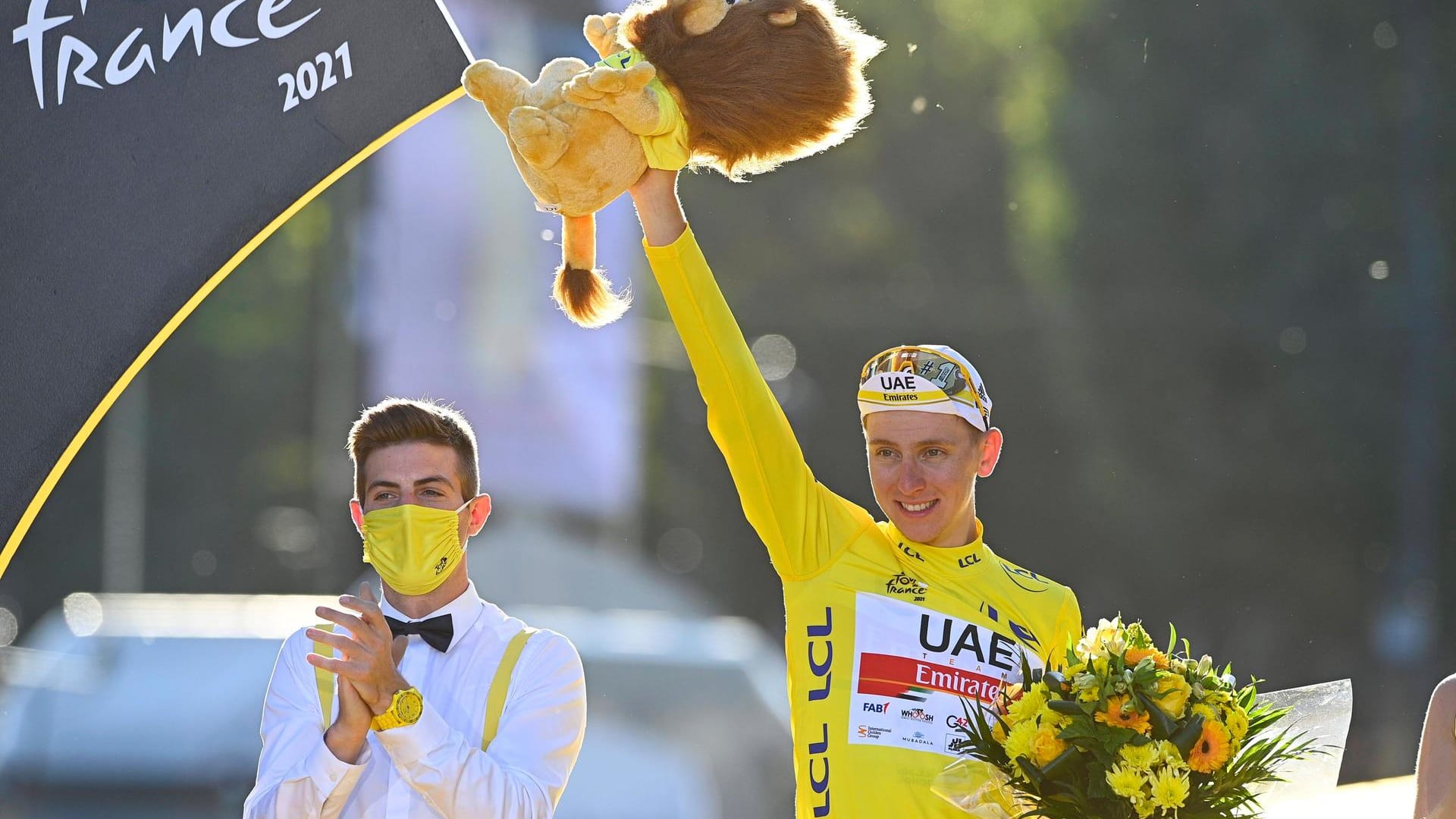 Tadej Pogacar (M.) wurde zum zweiten Mal in Folge auf dem Podium in Paris mit dem Gelben Trikot ausgezeichnet.