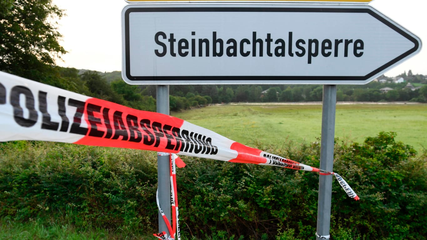 Ein Absperrband der Polizei ist am Hinweisschild zur Steinbachtalsperre befestigt: Die Menschen können in ihre Häuser zurückkehren.