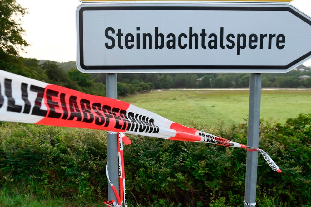 Ein Absperrband der Polizei ist am Hinweisschild zur Steinbachtalsperre befestigt: Die Menschen können in ihre Häuser zurückkehren.