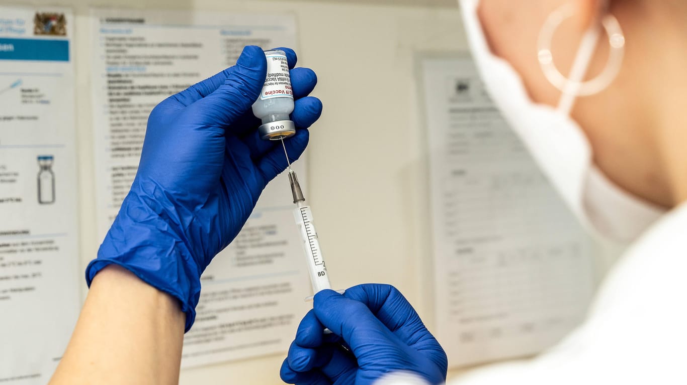 Eine Person zieht eine Spritze mit Impfstoff gegen das Coronavirus auf (Symbolbild): Hunderte Bremer müssen möglicherweise ein drittes Mal geimpft werden.