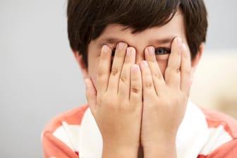 Ein Junge hält sich die Augen zu: Eine Bindehautentzündung kann ansteckend sein.