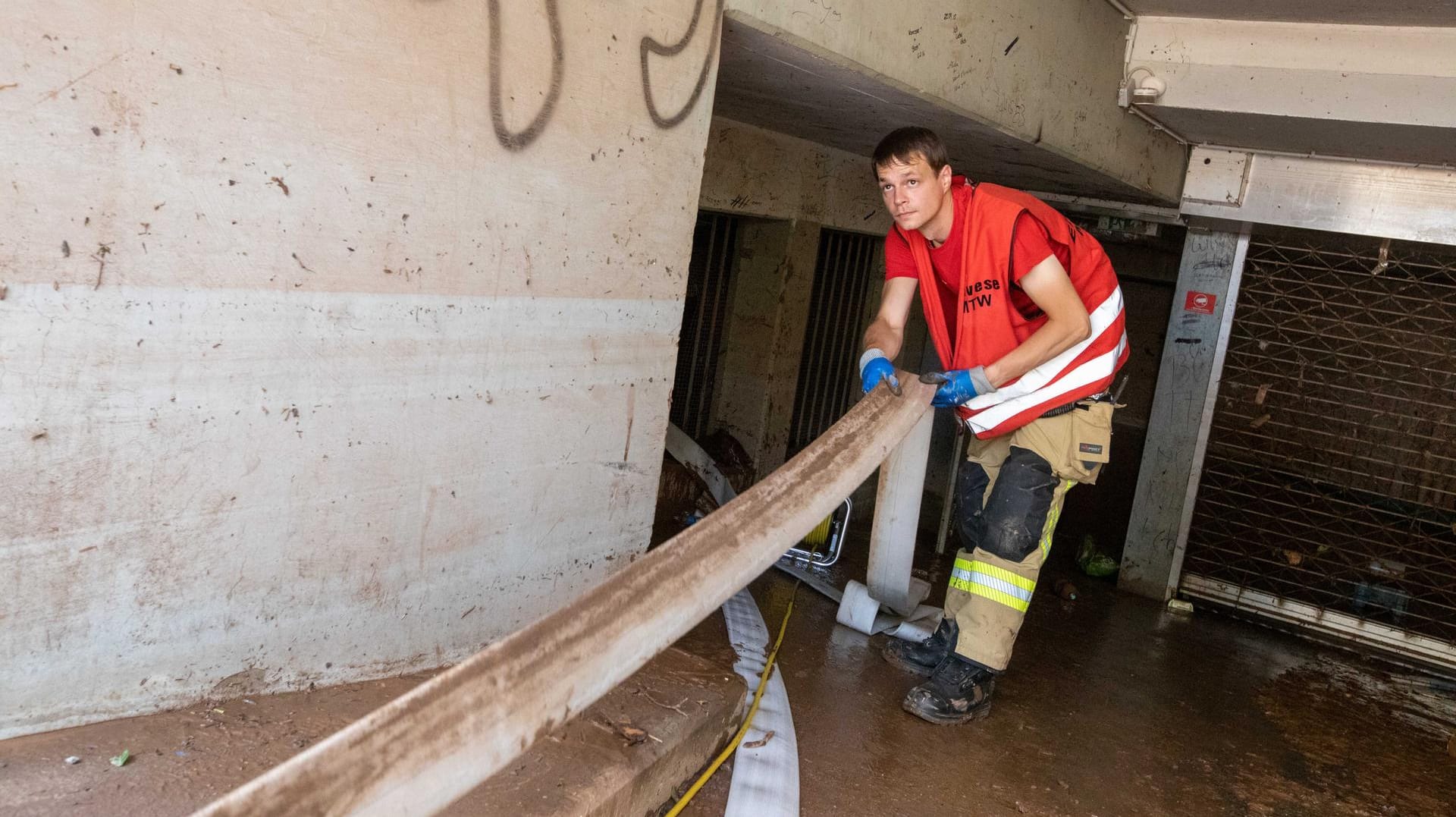 Kevin Schumann von der Freiwilligen Feuerwehr (FFW) Eilvese aus der Region Hannover zieht einen Schlauch in eine mit Wasser vollgelaufene Tiefgarage in Euskirchen: Der junge Mann will einfach "den Menschen helfen".