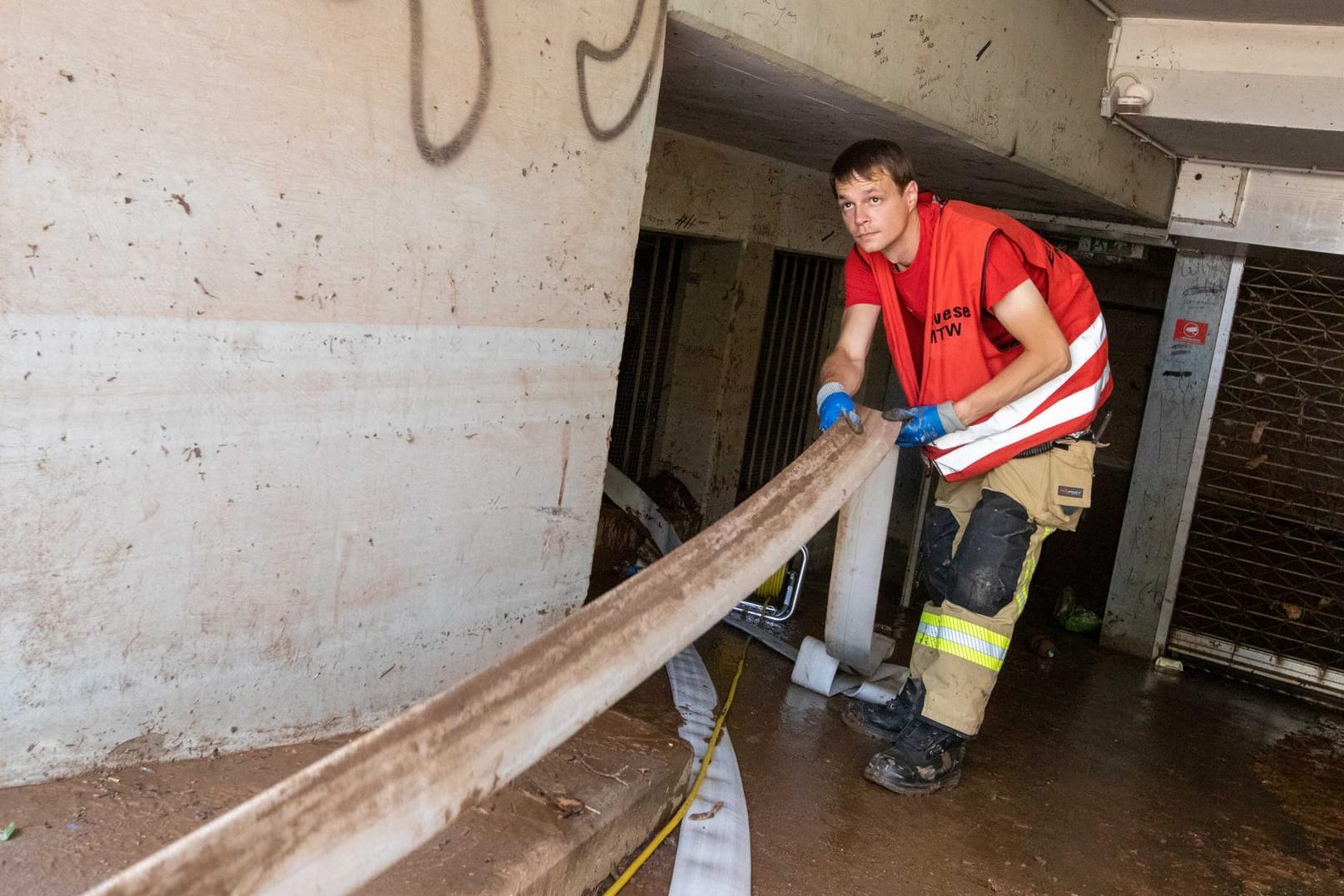 Kevin Schumann von der Freiwilligen Feuerwehr (FFW) Eilvese aus der Region Hannover zieht einen Schlauch in eine mit Wasser vollgelaufene Tiefgarage in Euskirchen: Der junge Mann will einfach "den Menschen helfen".