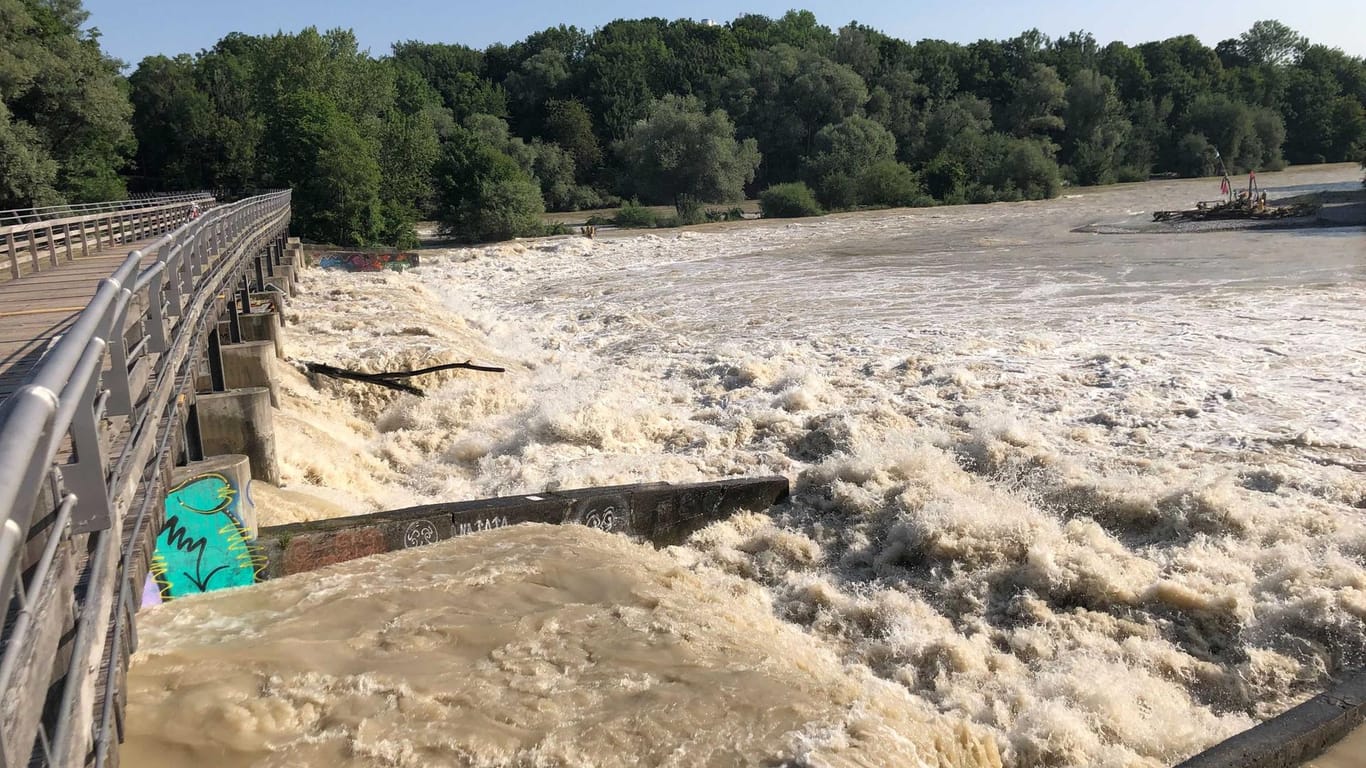 Braunes Wasser strömt die Isar hinunter, die auch Hochwasser führt: Baden und Bootfahren auf der Isar ist derzeit verboten.