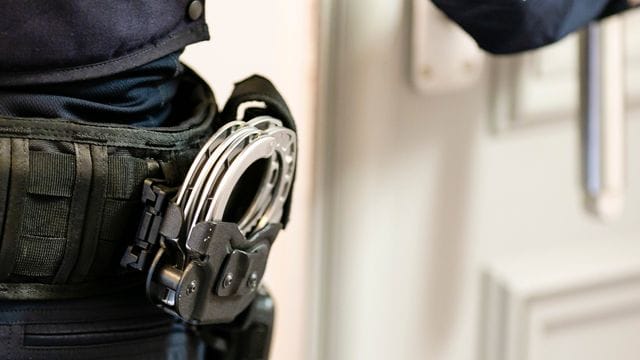 Handschellen sind an einem Gürtel eines Justizvollzugsbeamten befestigt (Symbolbild): Nach einer Durchsuchung seiner Wohnung wurde der Mann festgenommen. Handschellen sind an einem Gürtel eines Justizvollzugsbeamten befestigt (Symbolbild): Nach einer Durchsuchung seiner Wohnung wurde der Mann festgenommen.