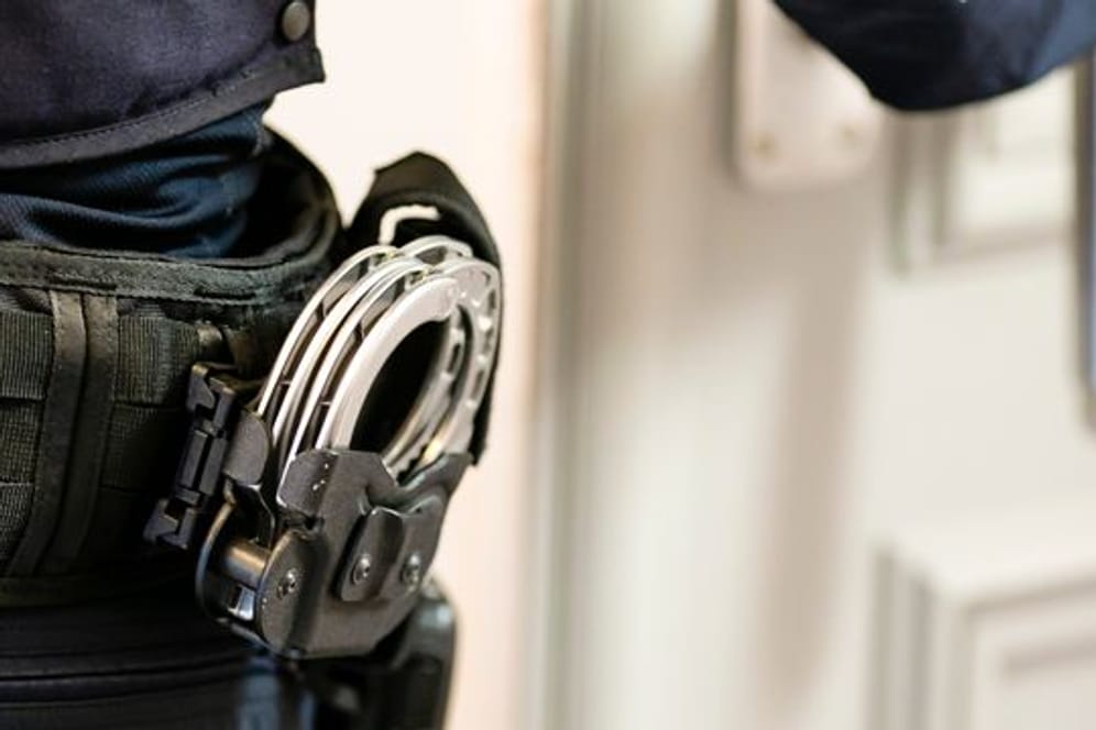 Handschellen sind an einem Gürtel eines Justizvollzugsbeamten befestigt (Symbolbild): Nach einer Durchsuchung seiner Wohnung wurde der Mann festgenommen.