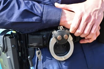 Handschellen am Gürtel eines Polizisten (Symbolbild): Die Polizei hatten mehrere mutmaßliche Plünderer festgenommen.