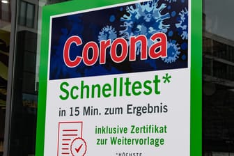"Corona-Schnelltest" steht in großen Buchstaben auf einem Plakat an einer Apotheke (Archivbild): An Kitas und Schulen soll das kostenlose Testangebot bestehen bleiben.