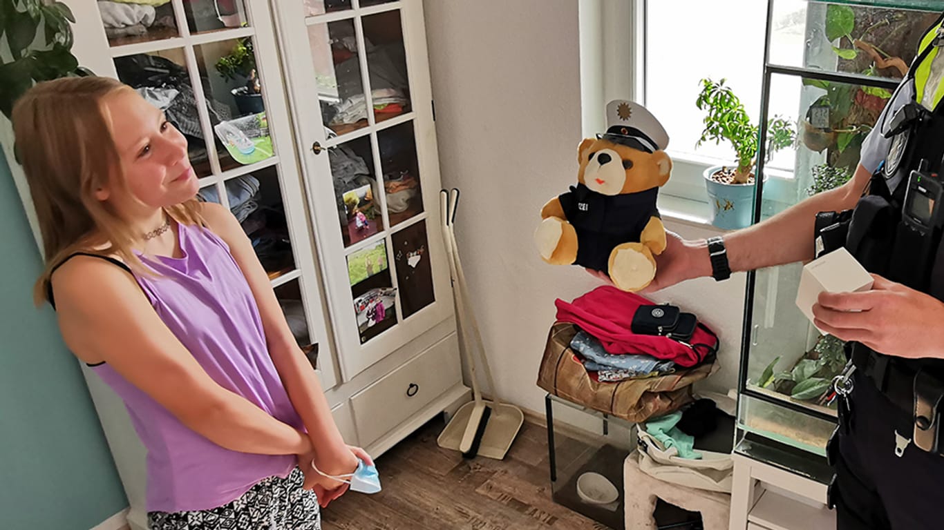 Ein Polizeibeamter überreicht der Kölnerin Sophie kleine Geschenke als Dankeschön für ihren mutigen Einsatz: Die Elfjährige hat einem Kleinkind am Fühlinger See das Leben gerettet.
