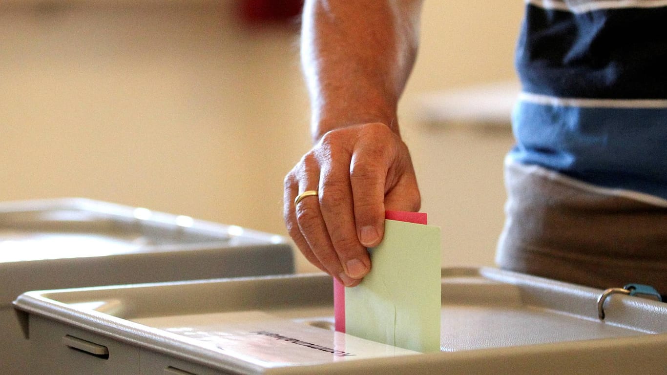 Ein Wahlumschlag wird in eine Wahlurne geworfen (Symbolbild): Im September steht die Bundestagswahl 2021 an.