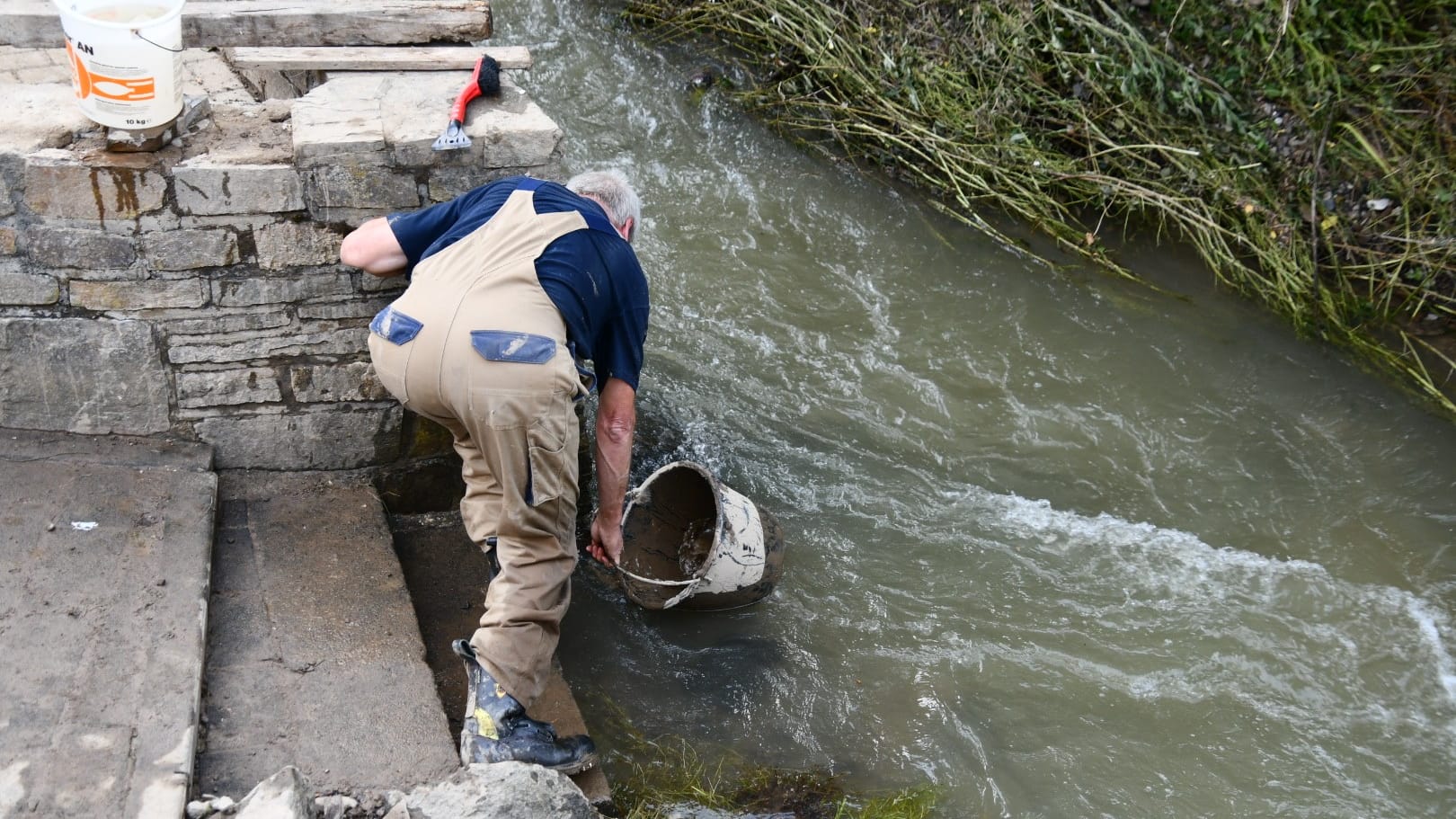 Ein Helfer holt Wasser. Rettungskräfte sind in Liers am Montag nicht zu sehen. Die Bewohner helfen sich selbst.