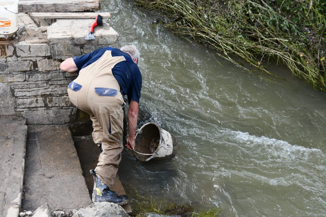 Ein Helfer holt Wasser. Rettungskräfte sind in Liers am Montag nicht zu sehen. Die Bewohner helfen sich selbst.