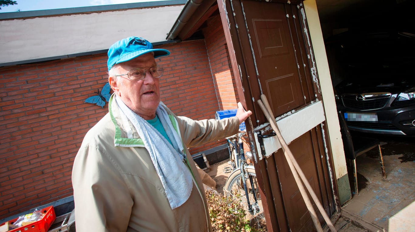 Anwohner Hans Christian (79) vor seiner Garage und dem defekten Auto: "Was Wasser für eine Kraft hat, das glauben Sie gar nicht."