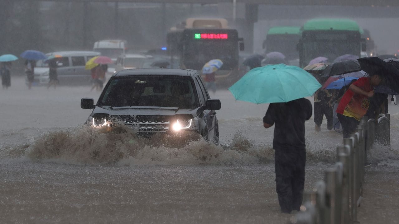 Ein Auto fährt in der zentralchinesischen Provinz Henan über eine überflutete Straße.
