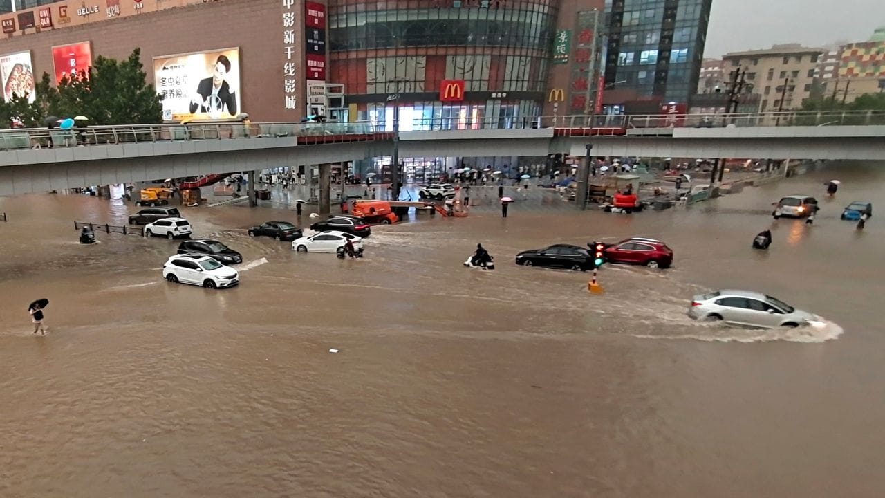 Fahrzeuge stehen in der zentralchinesischen Provinz Henan auf einer überfluteten Straße.