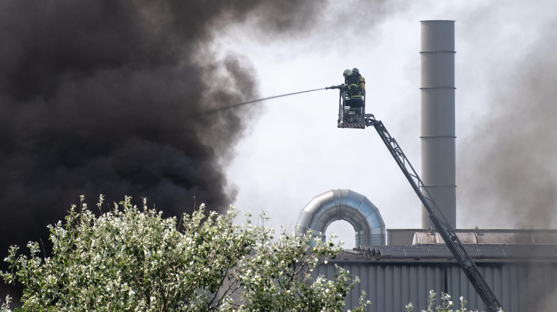 Feuerwehrleute bekämpfen von einer Drehleiter aus einen Brand in einer Lagerhalle: Die Lagerhalle eines Entsorgungsunternehmens in Erftstadt war aus noch ungeklärter Ursache in Brand geraten, sagte ein Feuerwehrsprecher. Feuerwehrleute bekämpfen von einer Drehleiter aus einen Brand in einer Lagerhalle: Die Lagerhalle eines Entsorgungsunternehmens in Erftstadt war aus noch ungeklärter Ursache in Brand geraten, sagte ein Feuerwehrsprecher.
