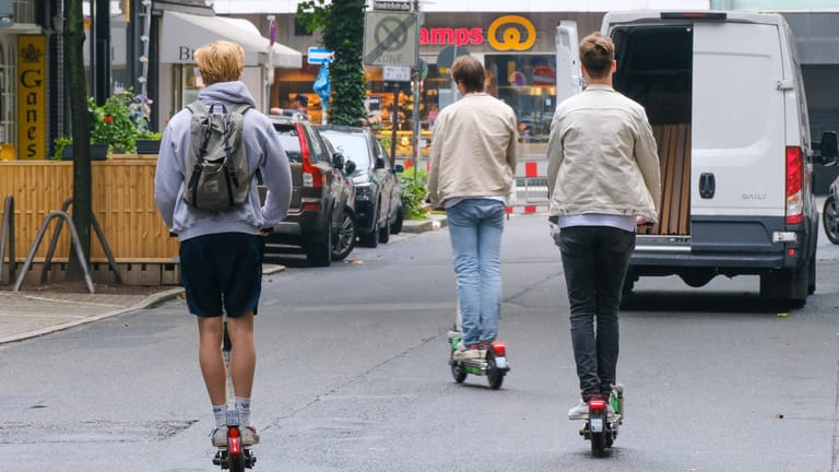 Drei E-Scooter-Nutzer fahren auf einer Straße (Symbolbild): In die Diskussionen um strengere Regulierung der Gefährte schaltet sich nun ein Anbieter ein.