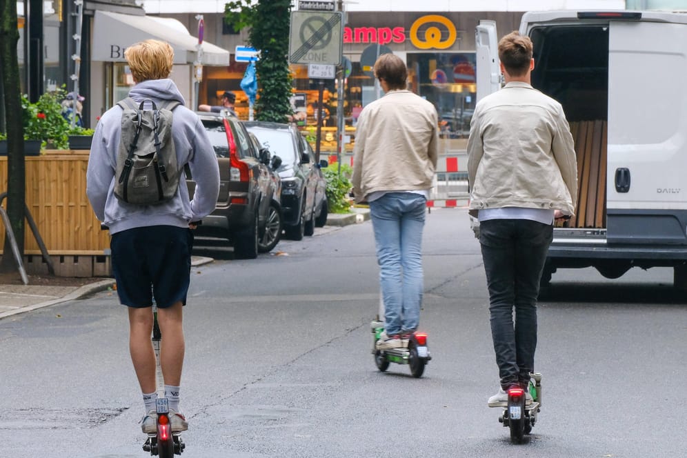 Drei E-Scooter-Nutzer fahren auf einer Straße (Symbolbild): In die Diskussionen um strengere Regulierung der Gefährte schaltet sich nun ein Anbieter ein.
