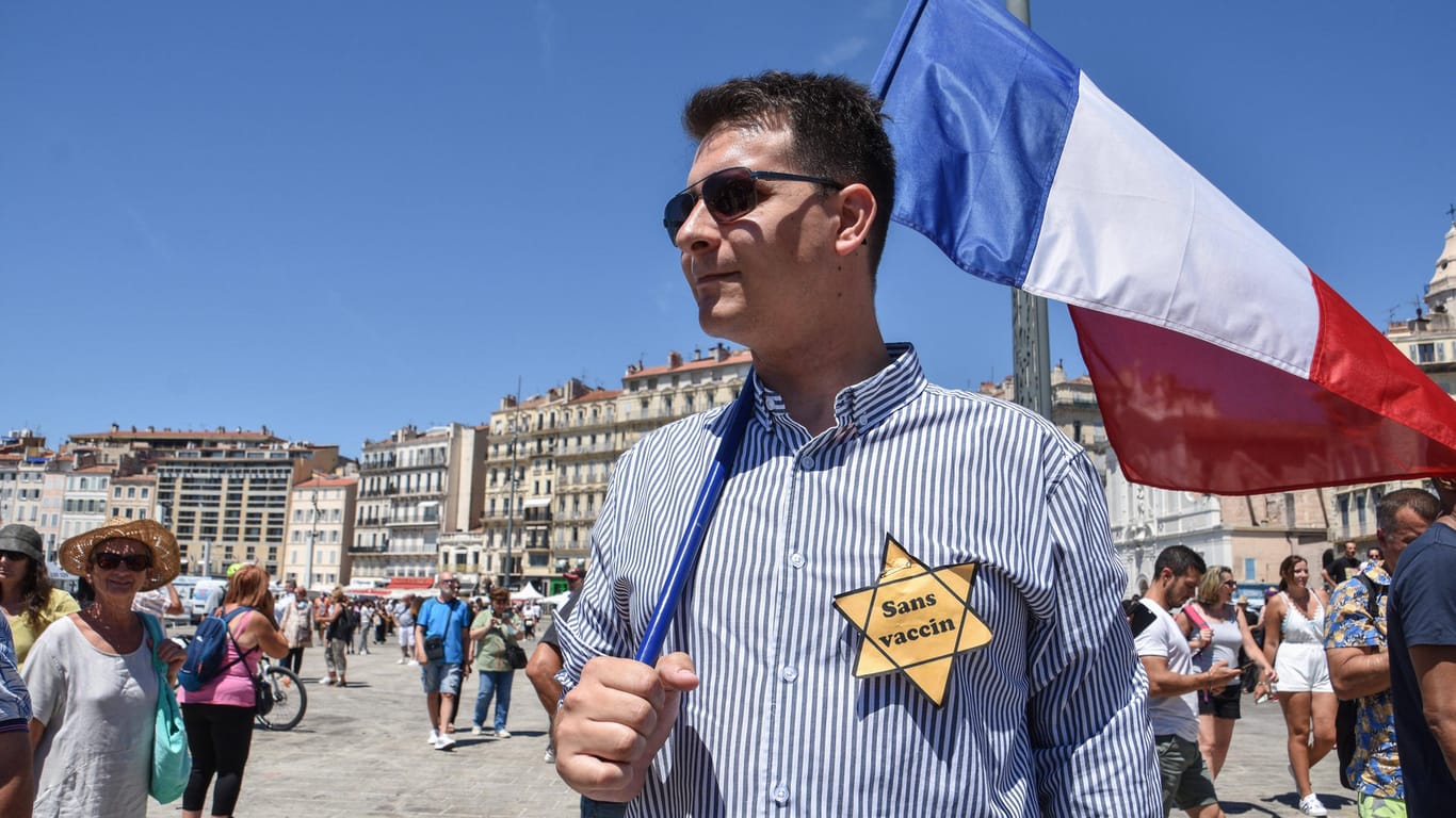 Marseille, Frankreich: Demonstrant mit französischer Flagge und Gelbem "Ungeimpft"-Stern.