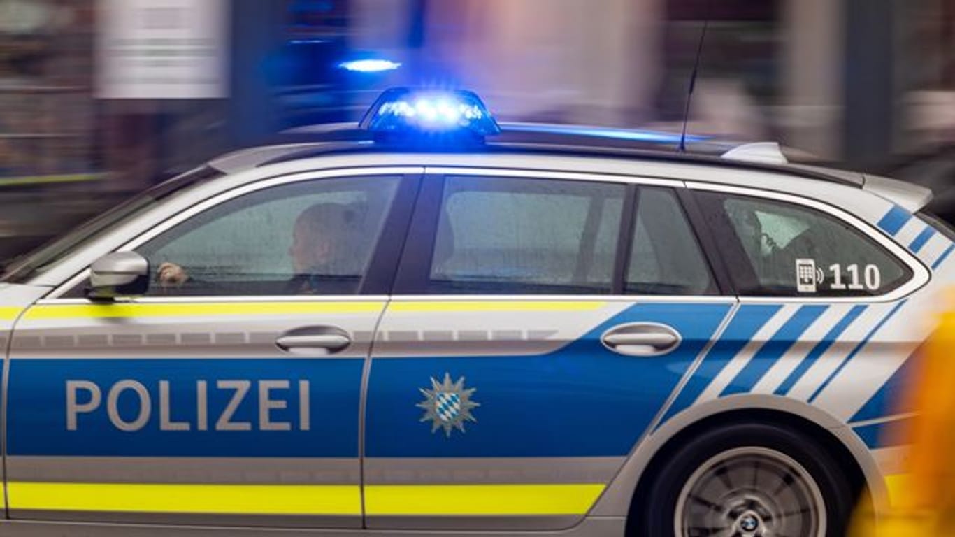 Ein Fahrzeug der bayerischen Polizei fährt mit Blaulicht durch die Innenstadt (Symbolbild): In Fürth wollte eine Frau einer Mutter ihr Kind wegnehmen.