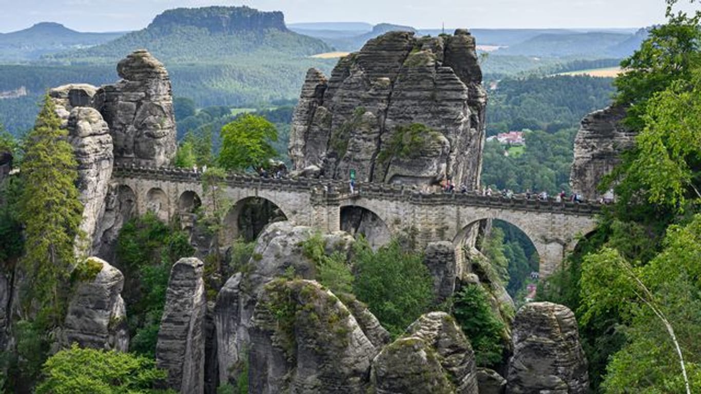 Touristen laufen in der Sächsischen Schweiz über die Basteibrücke