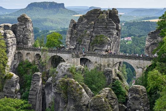 Touristen laufen in der Sächsischen Schweiz über die Basteibrücke