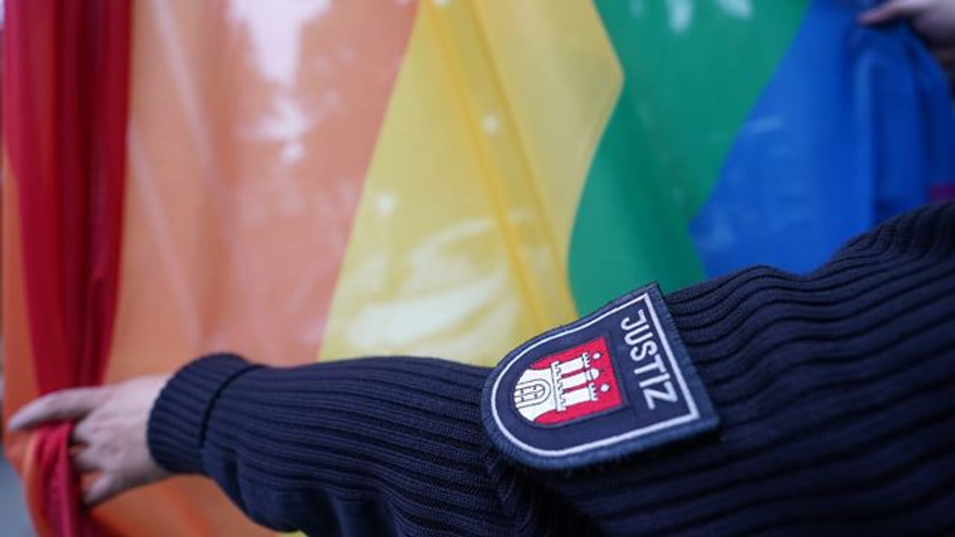 Ein Justizvollzugsbeamter befestigt eine Regenbogenflagge