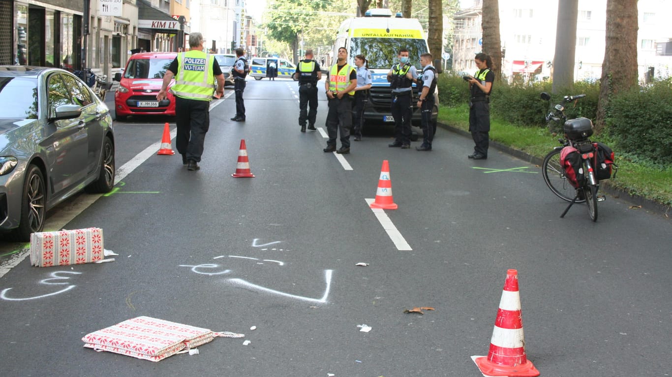 Polizisten stehen neben Pylonen und der Unfall-Markierung auf der Fahrbahn: Am Freitagmorgen kam es in Klettenberg zu einem schweren Unfall, eine Radfahrerin ist an ihren Verletzungen gestorben.