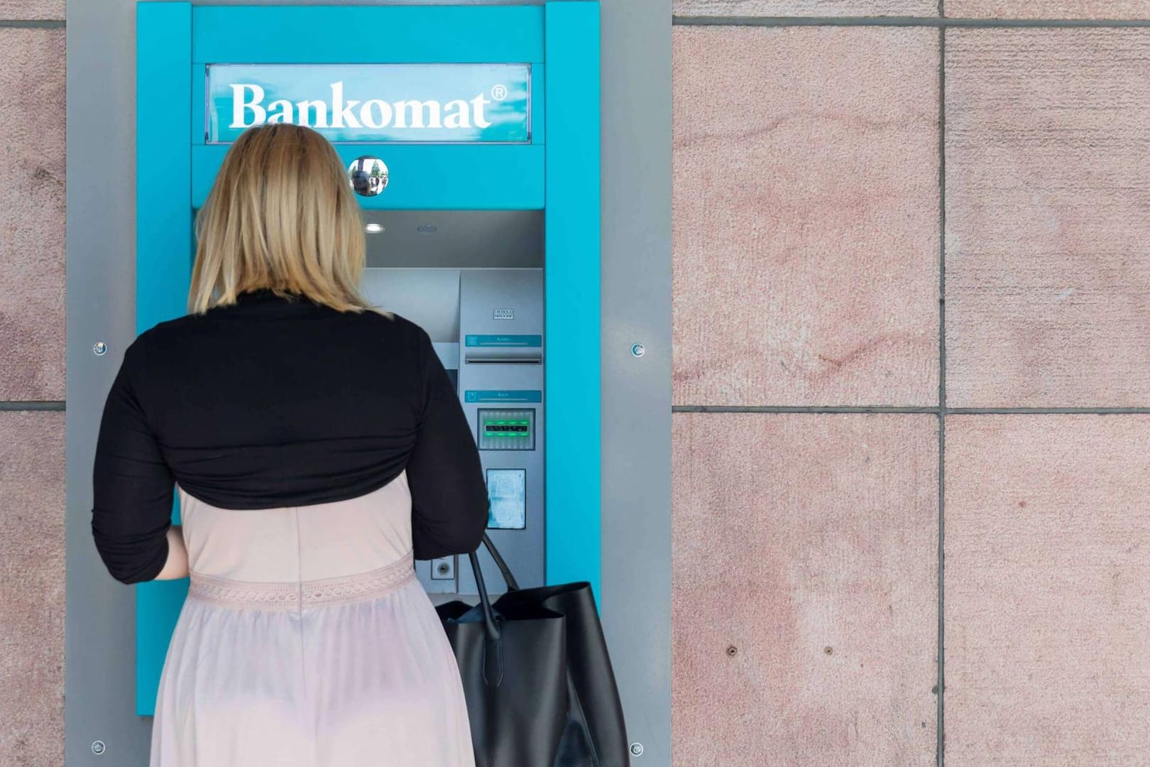 Eine Frau hebt Geld an einem Bankautomaten ab (Symbolbild): Wie können Frauen ihre Rente aufbessern?